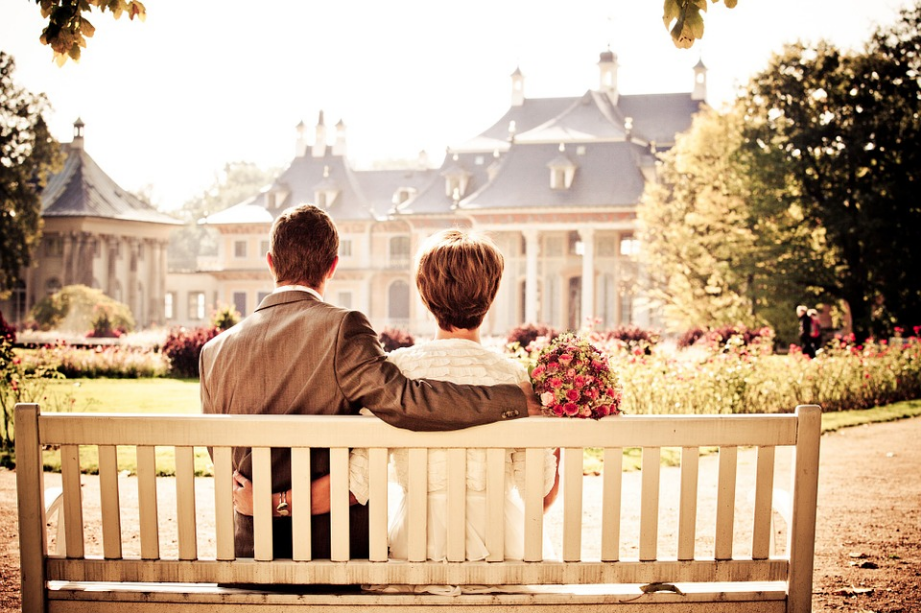 a newly-wed couple sitting on a bench